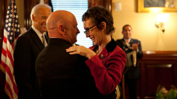 U.S. Rep. Gabrielle Giffords, still recovering from a bullet wound to the head, congratulates her husband, astronaut and Navy Capt. Mark Kelly, after he is honored by Vice President Joe Biden.