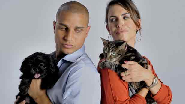 Brian Strong holding a Shih-Tzu puppy named Stabler and Karie Van Audal with a shy cat named Katy. 