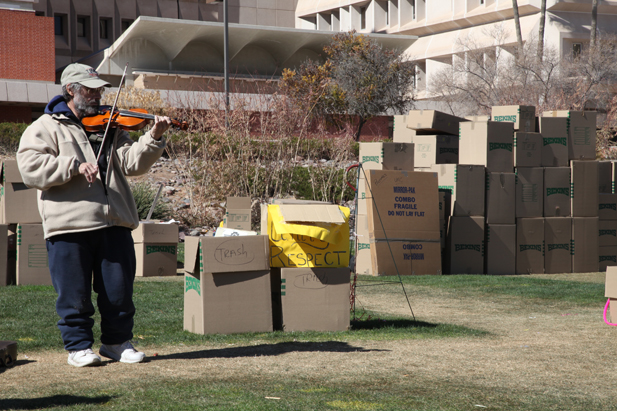 Violinist Michael Sigler plays on the UMC lawn as the memorial is packed up.