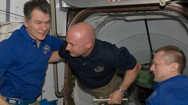 Endeavour Commander Mark Kelly (center) greets two members of the Expedition 27 crew shortly after docking with the International Space Station.