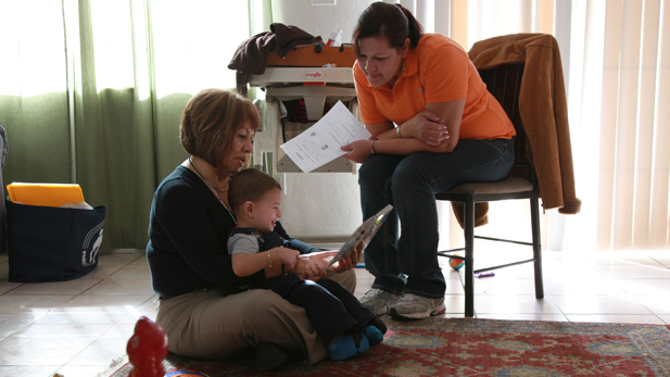 Raquel Cortez and her son, Christopher, are at home during a home visit from Patricia Escarcega (left), a Sunnyside School District educator.