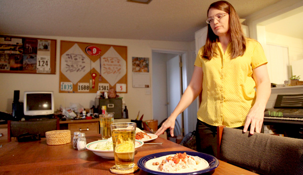 Samantha Dickens, in her dinning room serving dinner for her and her husband. All these food items were purchased as part of the SNAP challenge. 