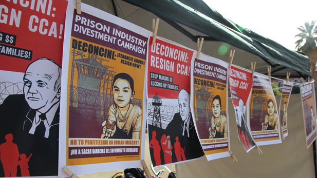 Posters calling for Dennis DeConcini to resign from the Corrections Corporation of America board hang near a protest during the Arizona Board of Regents Meeting Dec. 6, 2012. DeConcini is also a member of the Board of Regents.