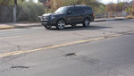 Potholes pit a section of road in Tucson.