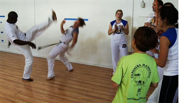 Anne Pollack and Mestre Lombão play capoeira during an roda 