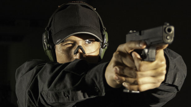 A firearms instructor at F6 Labs in Hicksville, New York, firing a Glock.