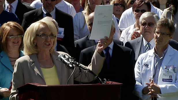 Gov. Jan Brewer shows off her 7-page Medicaid expansion bill at March 12, 2013 state Capitol rally.