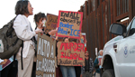 Protestors stand at the site where a 16-year-old boy was shot and killed on the Mexican side of the border by Border Patrol in October 2012.