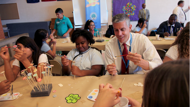 U.S. Secretary of Education Arne Duncan painting with Simone Ufondu, 11, at Dodge Middle School.