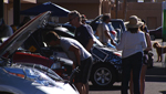 Event visiters look at new model electric cars at the Tucson Plugs In event.