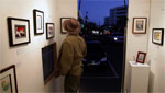 Man looks at pieces of art on display in a mobile art gallery.