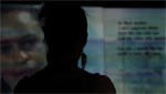 Performer (silhouetted) standing in front of a project background.
