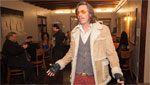 Man wearing a jacket poses for photo in restaurant.