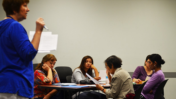 Volunteer tutor Kathy Zuodar teaches a group of students the difference between "could" and "would."

