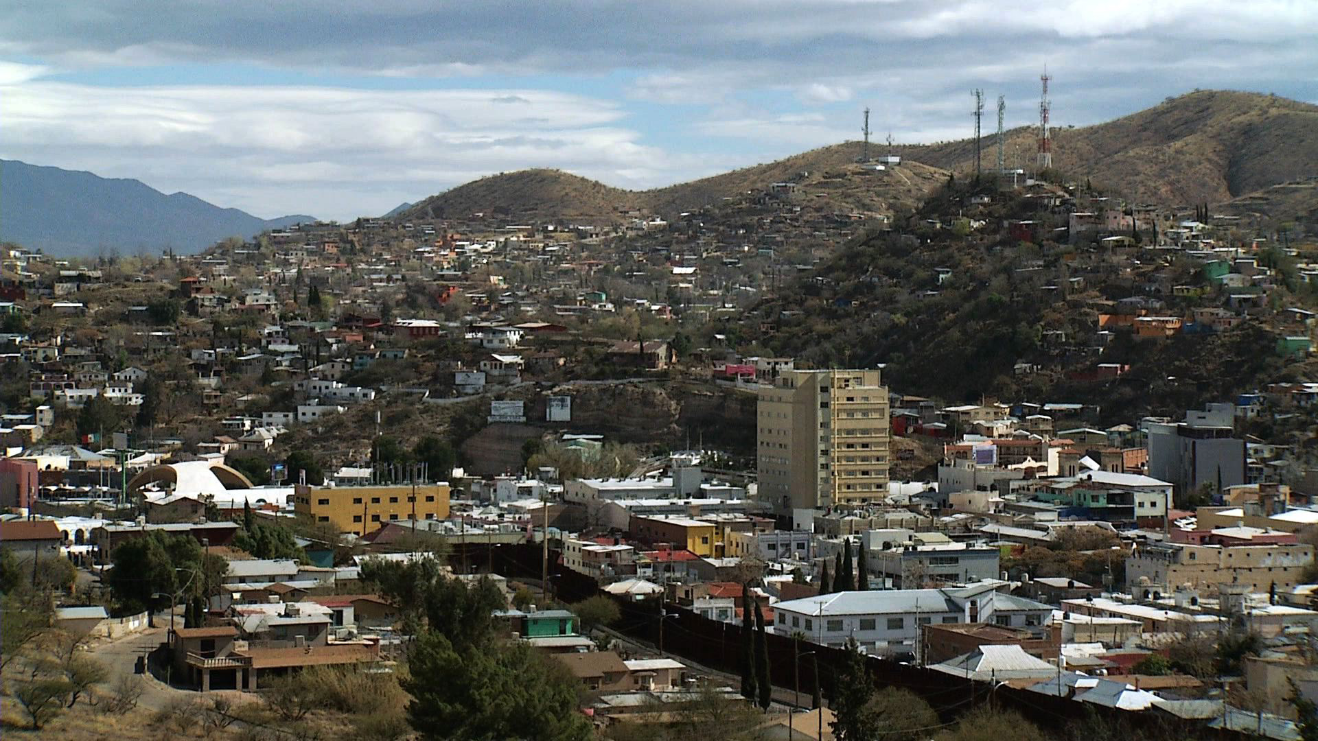 The border of Nogales, Arizona and Nogales, Mexico is separated by a large brown metal fence. 