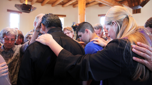 Daniel Neyoy Ruiz is surrounded by supporters praying at Southside Presbyterian Church