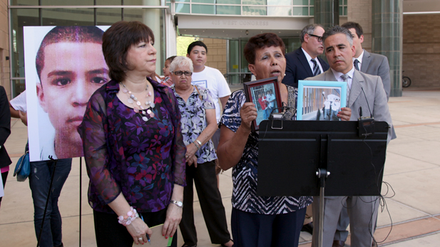 Taide Elena, Jose Antonio's grandmother, shows a photo of the teen next to an image of his coffin at the border.