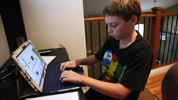 Ricky Helmboldt,12, works on food web on his tablet computer at home. He says science is his favorite subject. 
