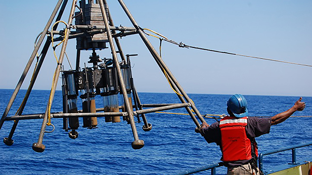 Collecting sediment cores aboard a ship.