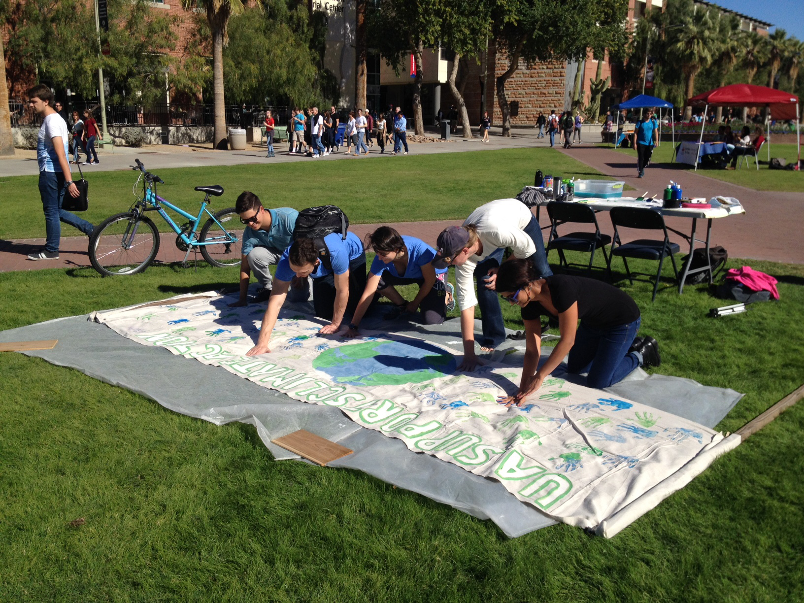 Students at the University of Arizona add their hand prints to a banner that will be displayed at the United Nations Climate Conference in Paris.