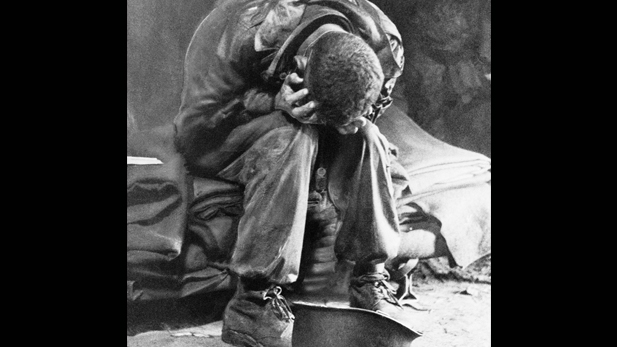 An American soldier collapses in his hands from the strain of fighting along the Taegu front, South Korea, 1950.