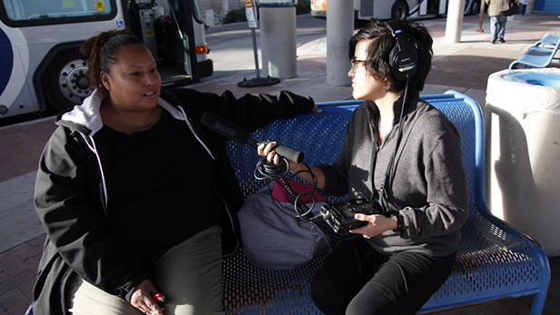 Christina Hamaley talks about her life in Tucson while waiting for a bus at Roy Laos Transit Center. Pictured with producer Sophia Paliza-Carre.