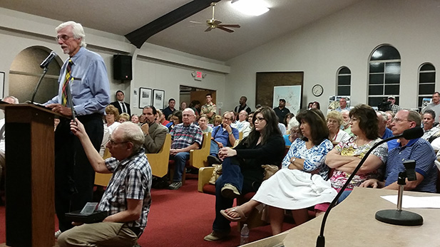 St. David resident Don Buchanan (left) addresses the Benson City Council in front of a packed house Monday night, speaking against the Villages at Vigneto due to concerns over water use.