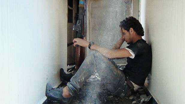 Protagonist Basset Al-Sarout rests in a bombed out apartment building in shattered Homs.