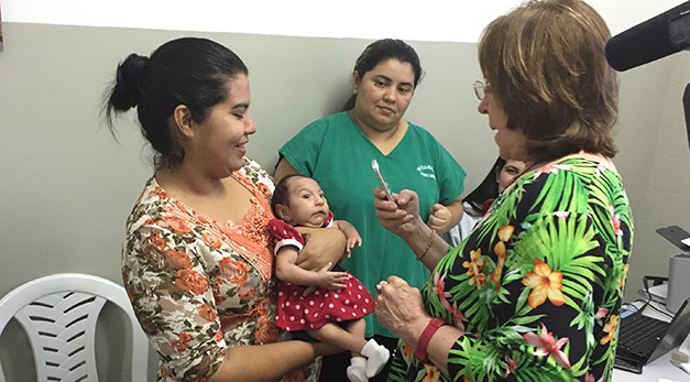 At Candido Vargas Institute in João Pessoa, Brazil, a geneticist examines an infant with microcephaly, a brain defect associated with Zika virus infection.