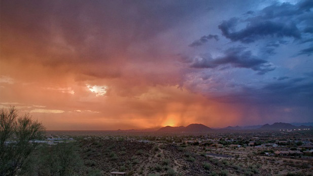 The sun sets through afternoon showers.
