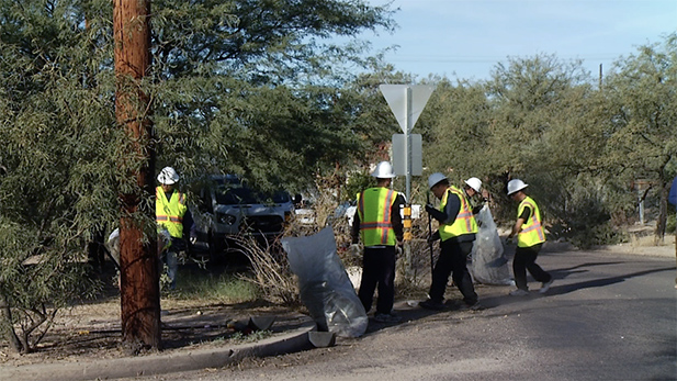 Homeless Work Program participants clean a city street.