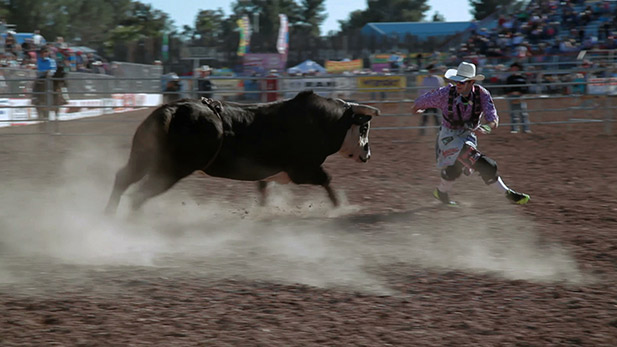Dusty Tuckness, a rodeo clown, evades a bull.