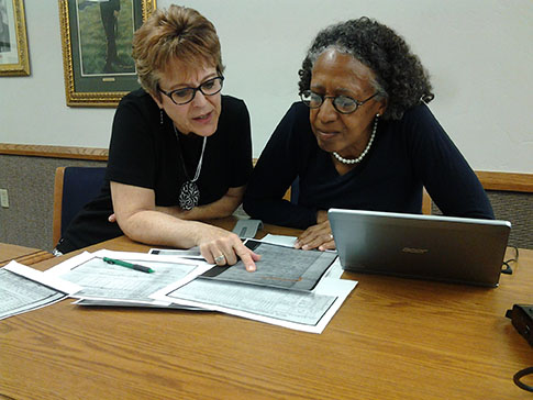 Debbie Weitzell, left, and Stephanie Gelsinon scan Freedmen Bureau documents.