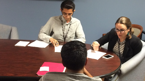 Legal assistant Javier Hernandez and lawyer Sara Van Hofwegen of Public Counsel meet with a teenage client from Guatemala who is applying for asylum.