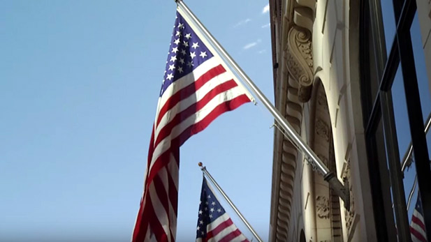American Flags hang from a building.