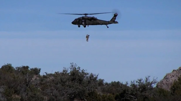 Survival trainees rappel from a helicopter.