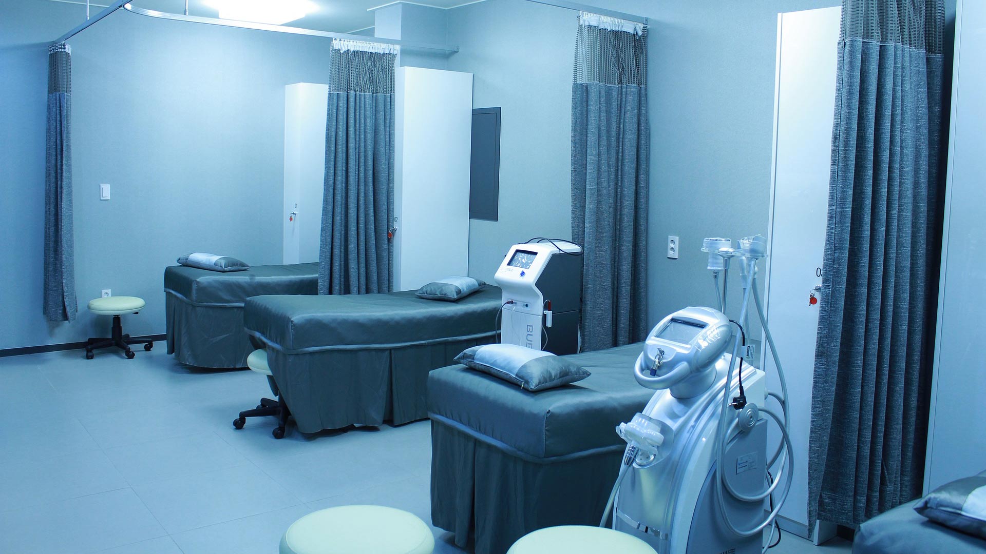 Hospital beds lined up in a room.