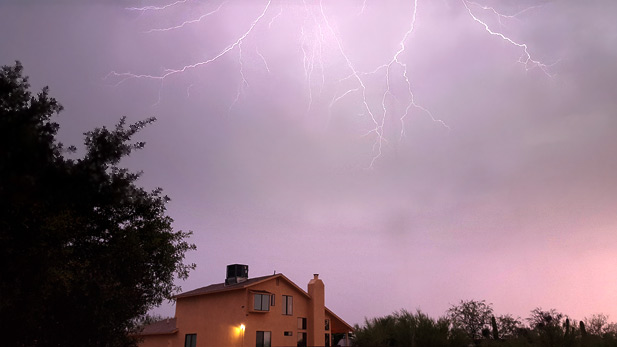 Lightning flashes over a house on Tucson's far east side during a monsoon storm.