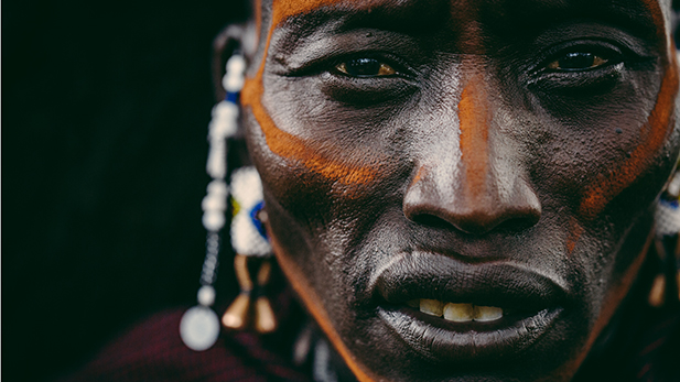 Close up of a Maasai warrior's face pained with ochre.