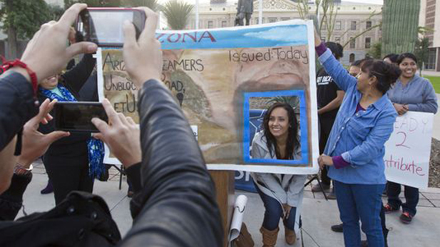 A woman poses in a drivers license at a demonstration in support of "dreamers."