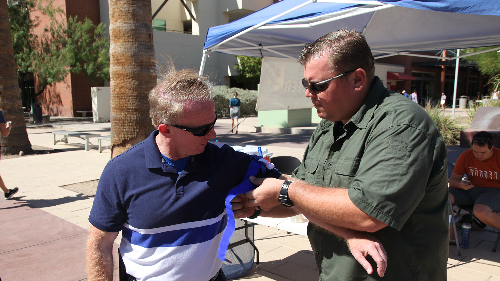 ICSAVE's Bruce Whitney (left) and Mark Lytle (right) demonstrate how to use a tourniquet. Both men work for fire departments in the Tucson area and volunteer with the group.