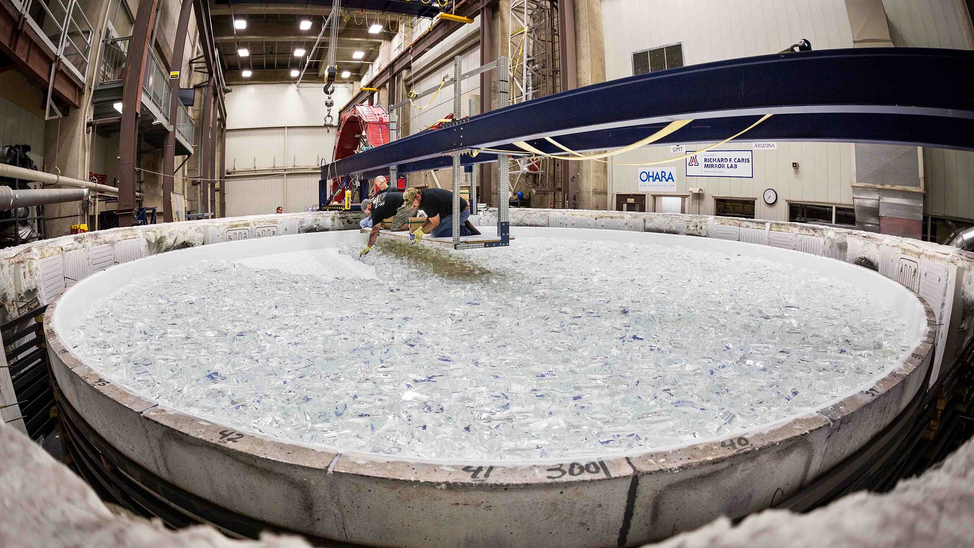 Workers at the University of Arizona's Richard F. Caris Mirror Lab place glass in the furnace for the 5th mirror for the Giant Magellan Telescope, October 2017.