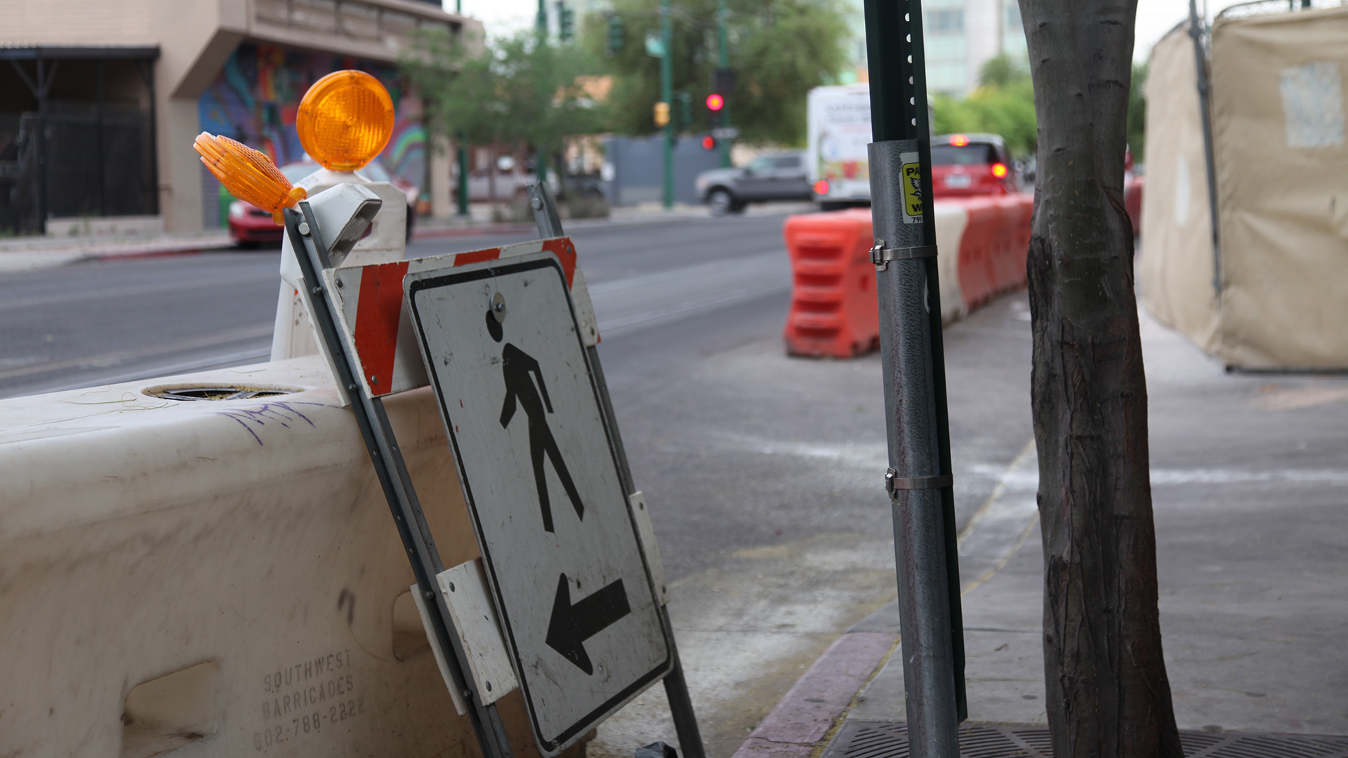 A sign directing pedestrians on a street in downtown Tucson.