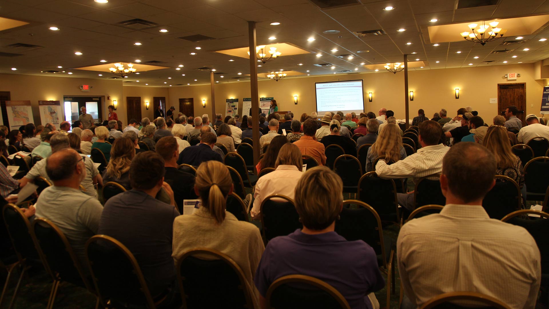 People listening to a presentation at an ADOT public meeting on Interstate 11 in Tucson.