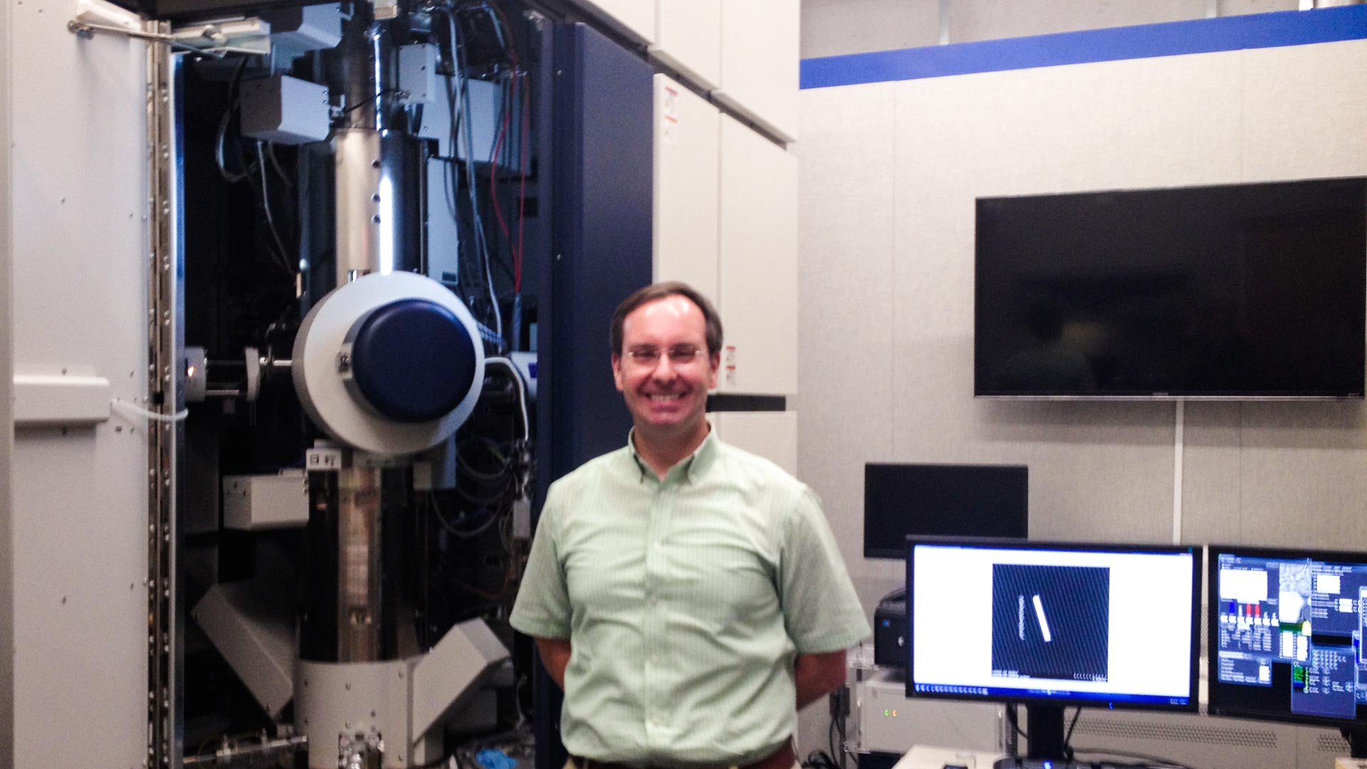 Planetary scientist Tom Zega with the UA Lunar and Planetary Laboratory's transmission electronic microscope which will analyze dirt samples returned from the asteroid Bennu in 2023. The instrument has serial number 1. 