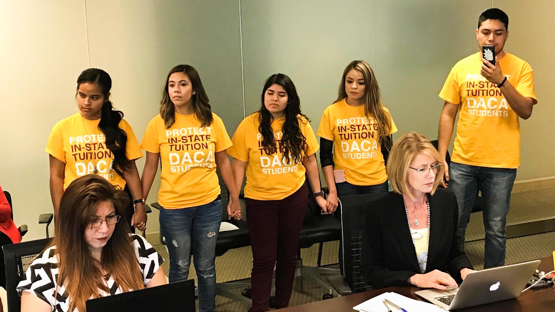 A group stands in support of in-state tuition eligibility for students in Arizona with DACA status at a June 29, 2017, Arizona Board of Regents meeting.