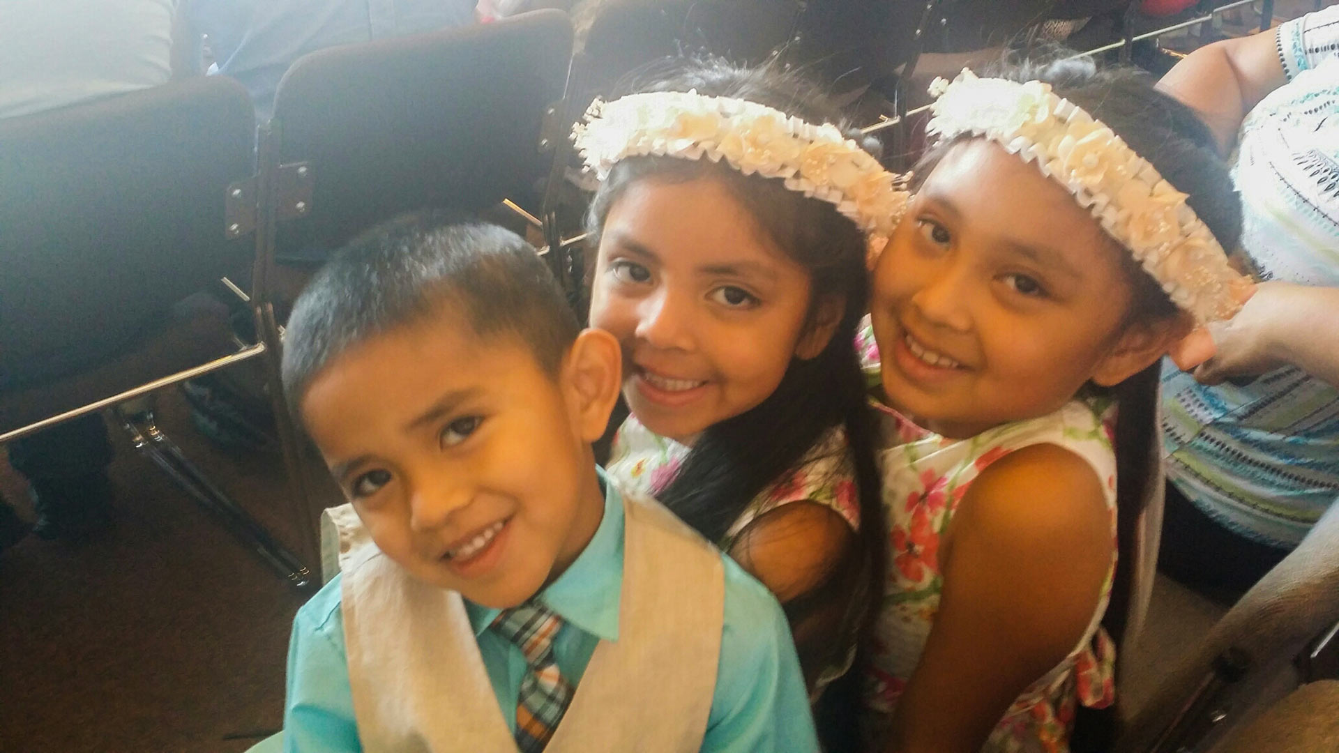 Three siblings watch as mother keeps her promise to become a U.S. Citizen.