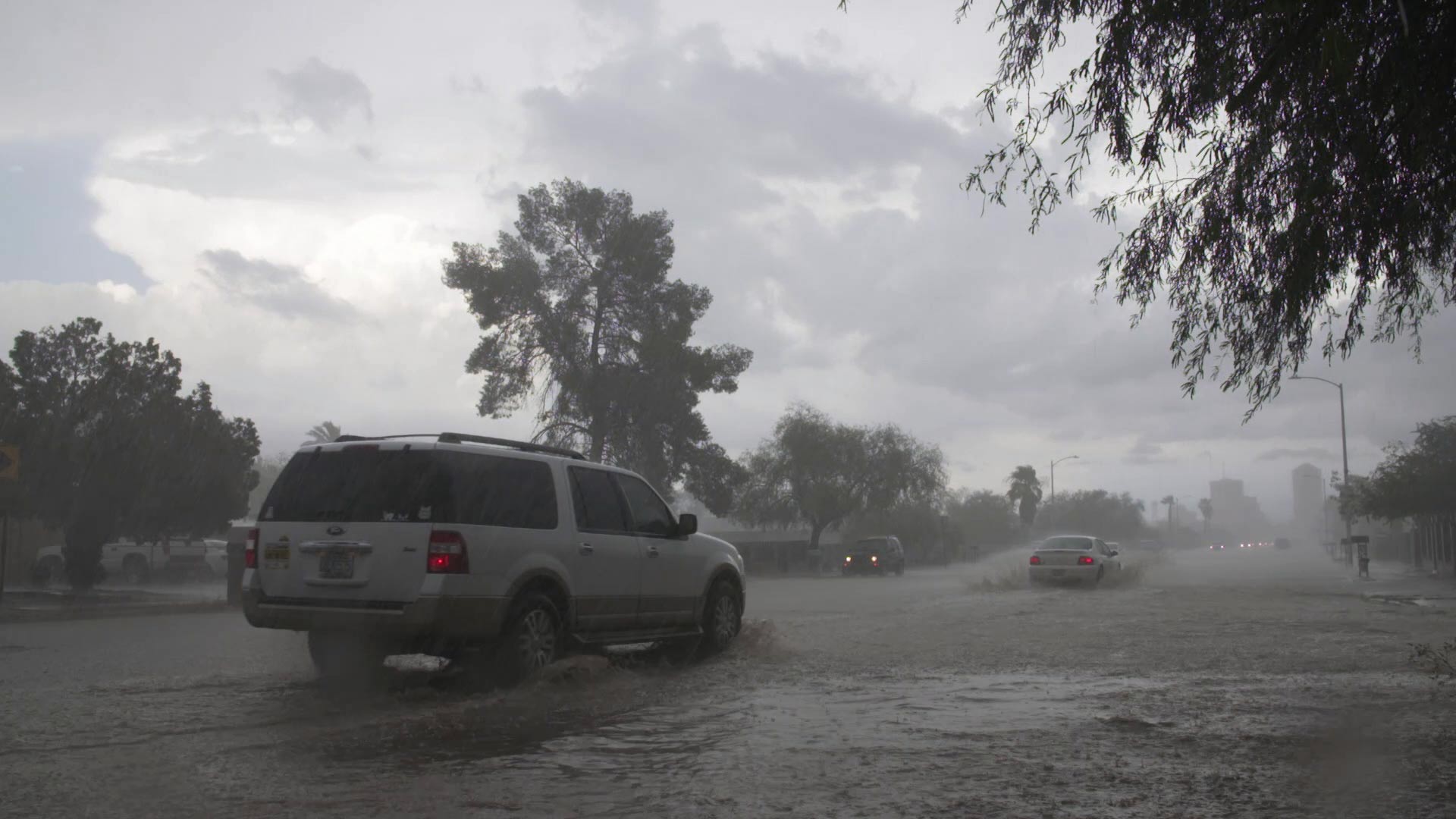 Cars drive through flooded streets during a monsoon storm. From July 2017.