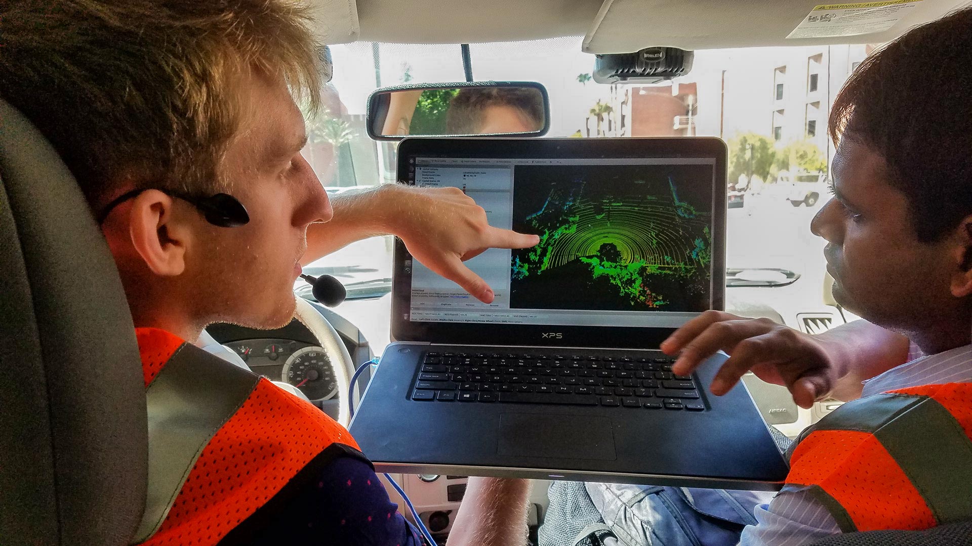 George Gunter (left) and Rahul Bhadani (right) show the data from a more advanced sensor attached to the roof of the "cognitive and autonomous test vehicle." The goal of their project was to get similarly accurate data with a sensor that records less data.