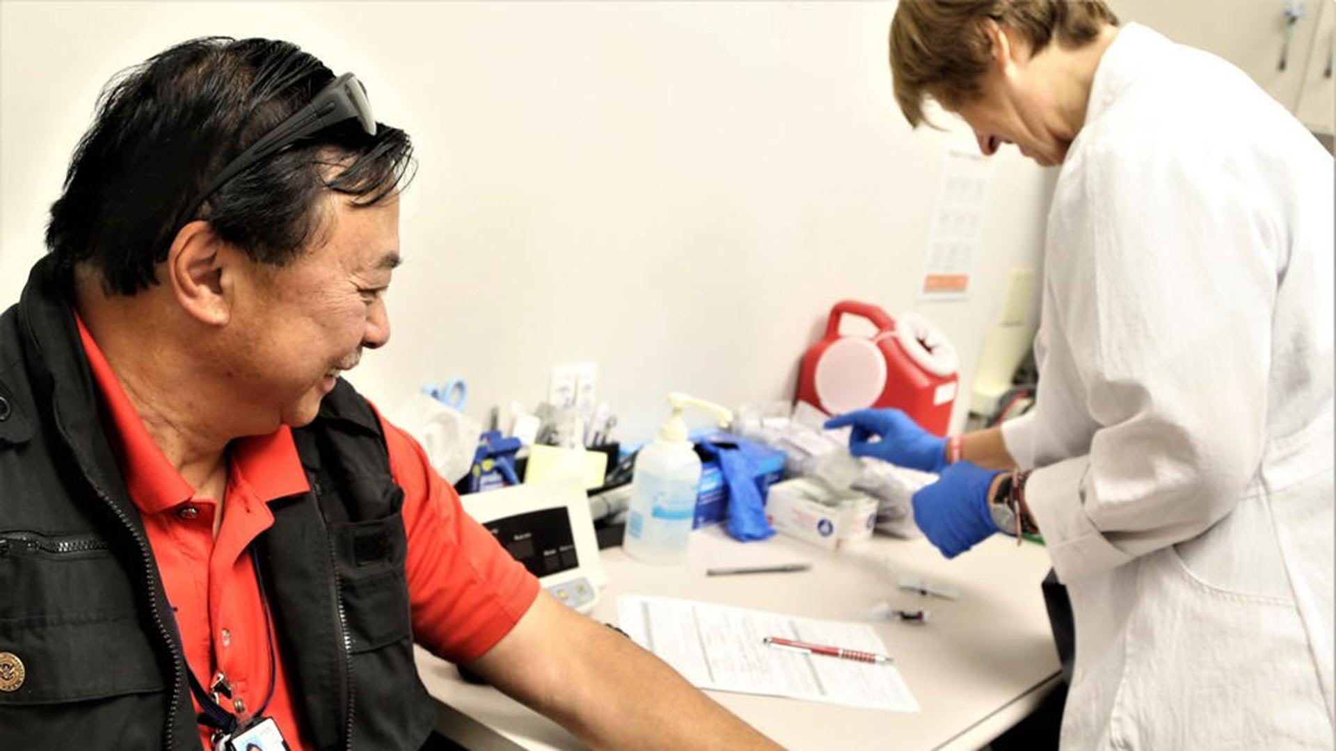 A man gets ready to receive a flu shot, 2016.